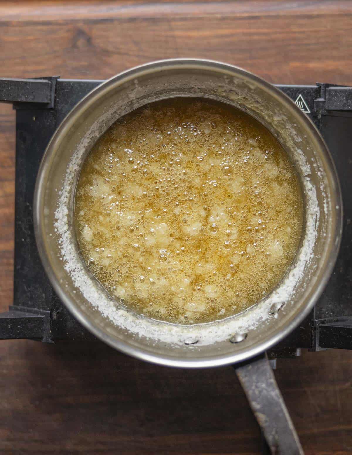 Water and sugar slowly turning yellow and caramelizing. 