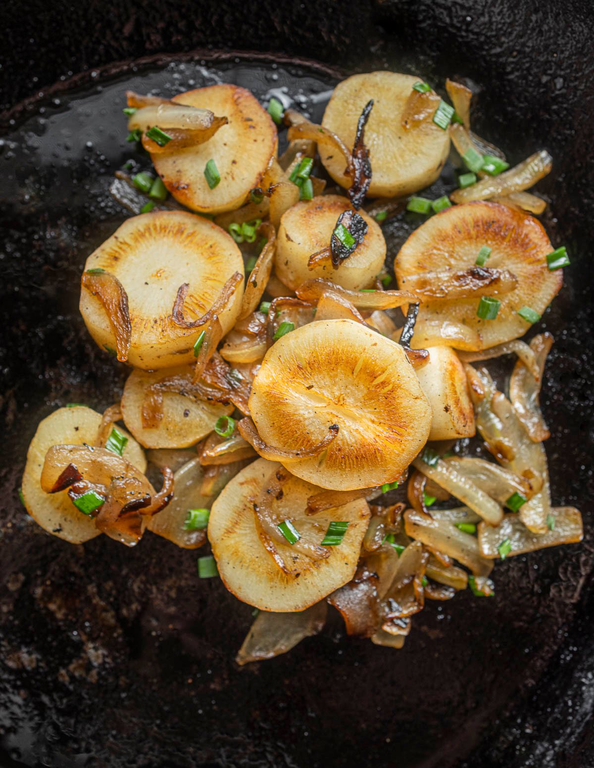 Fried rounds of yellow salsify root mixed with caramelized onions. 