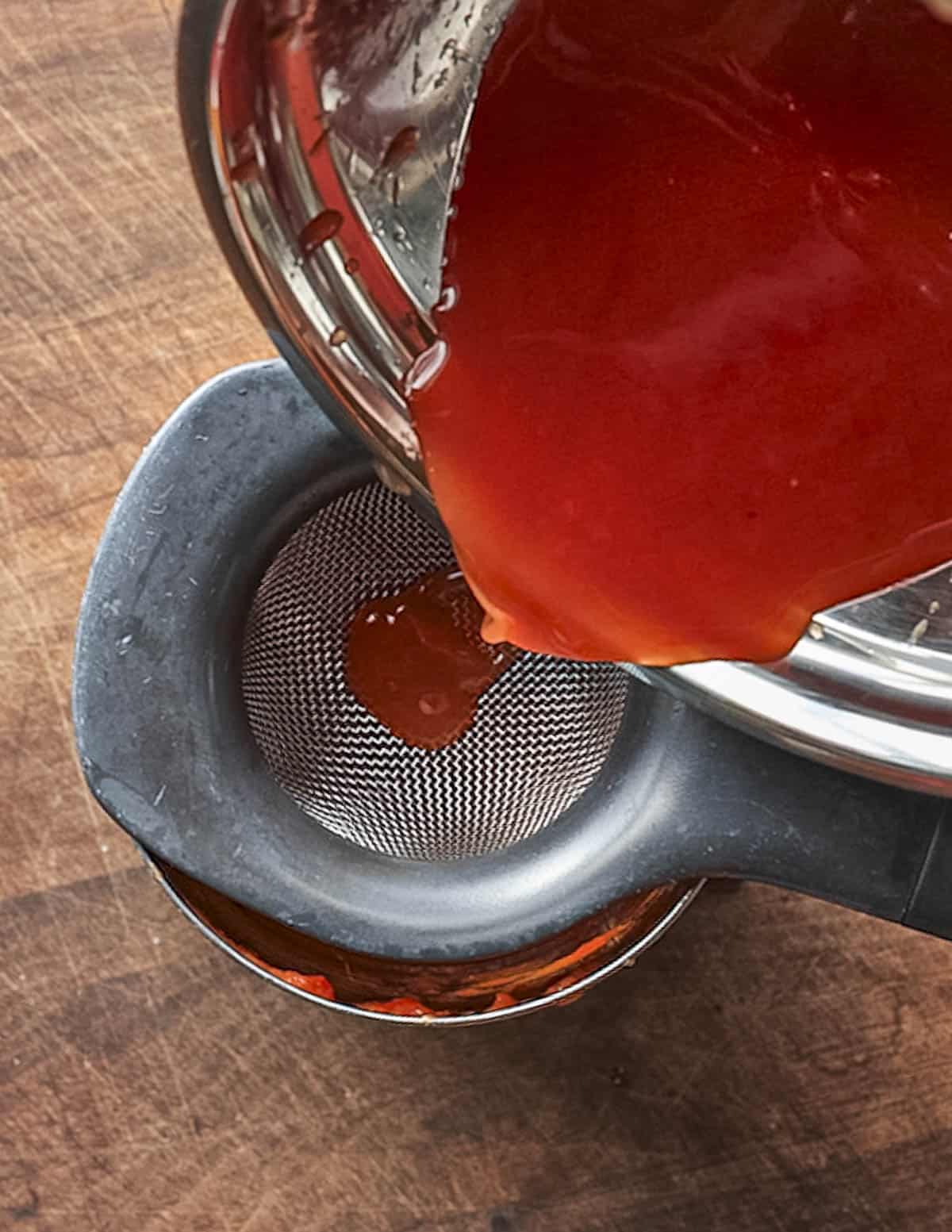 Straining the juice from a can of whole peeled tomatoes. 