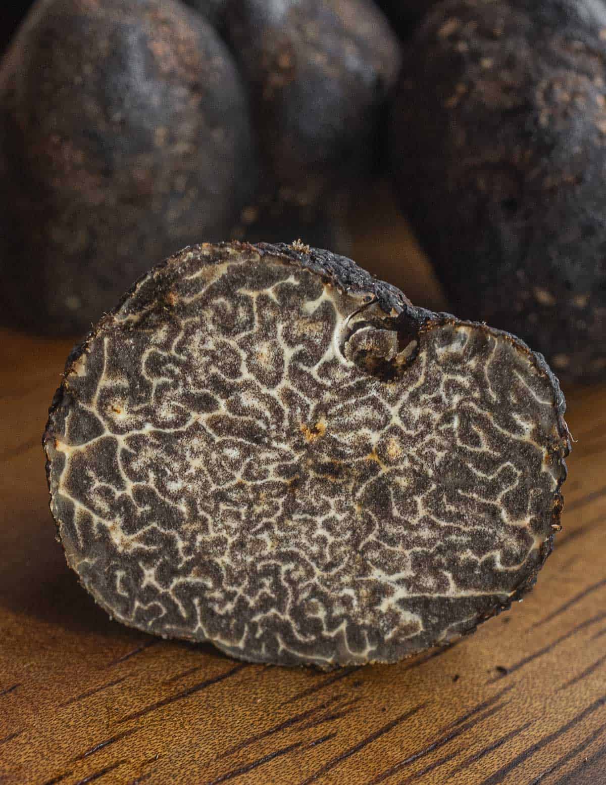 A close up image of Tuber macrosporum truffles showing the inner gleba and discoloration from bug damage. 