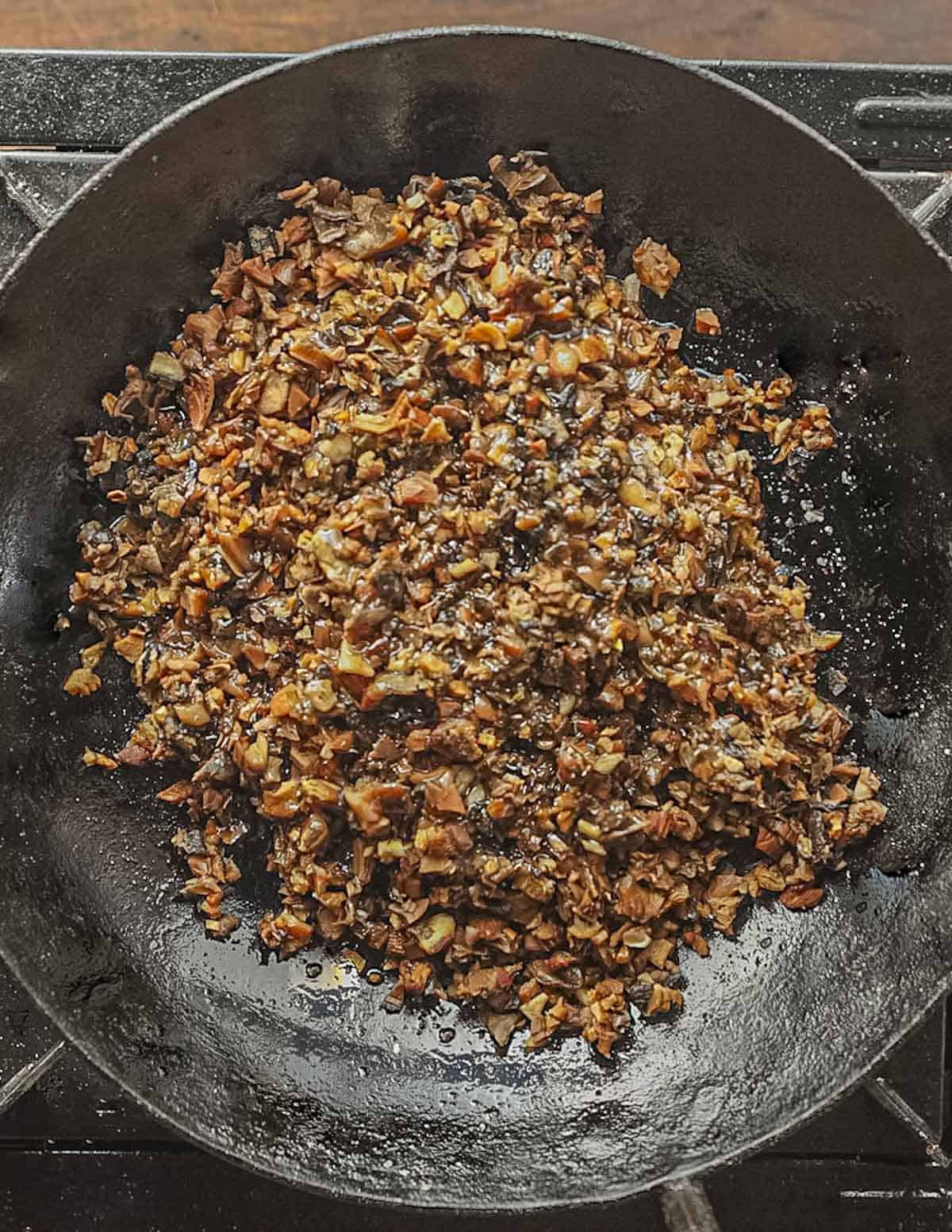Minced dried mushrooms in a pan ready to go into the oven. 