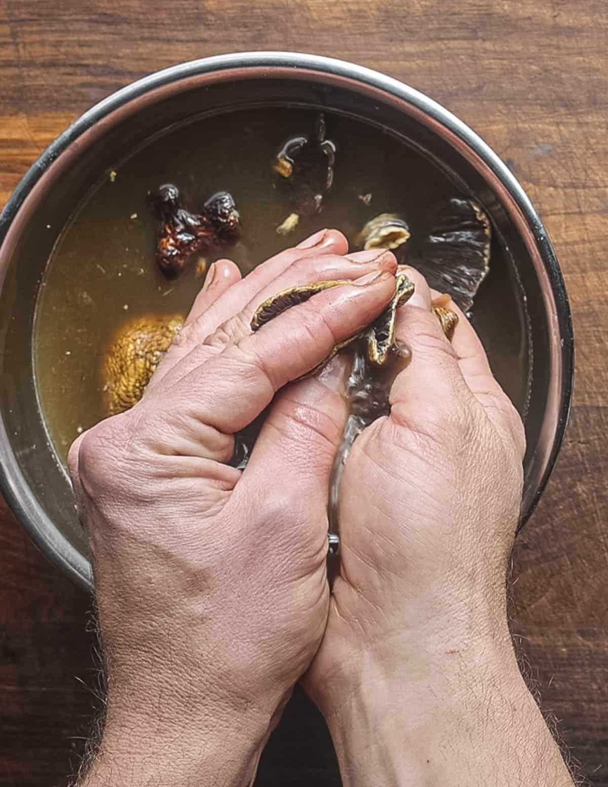 Squeezing liquid from dried mushrooms. 