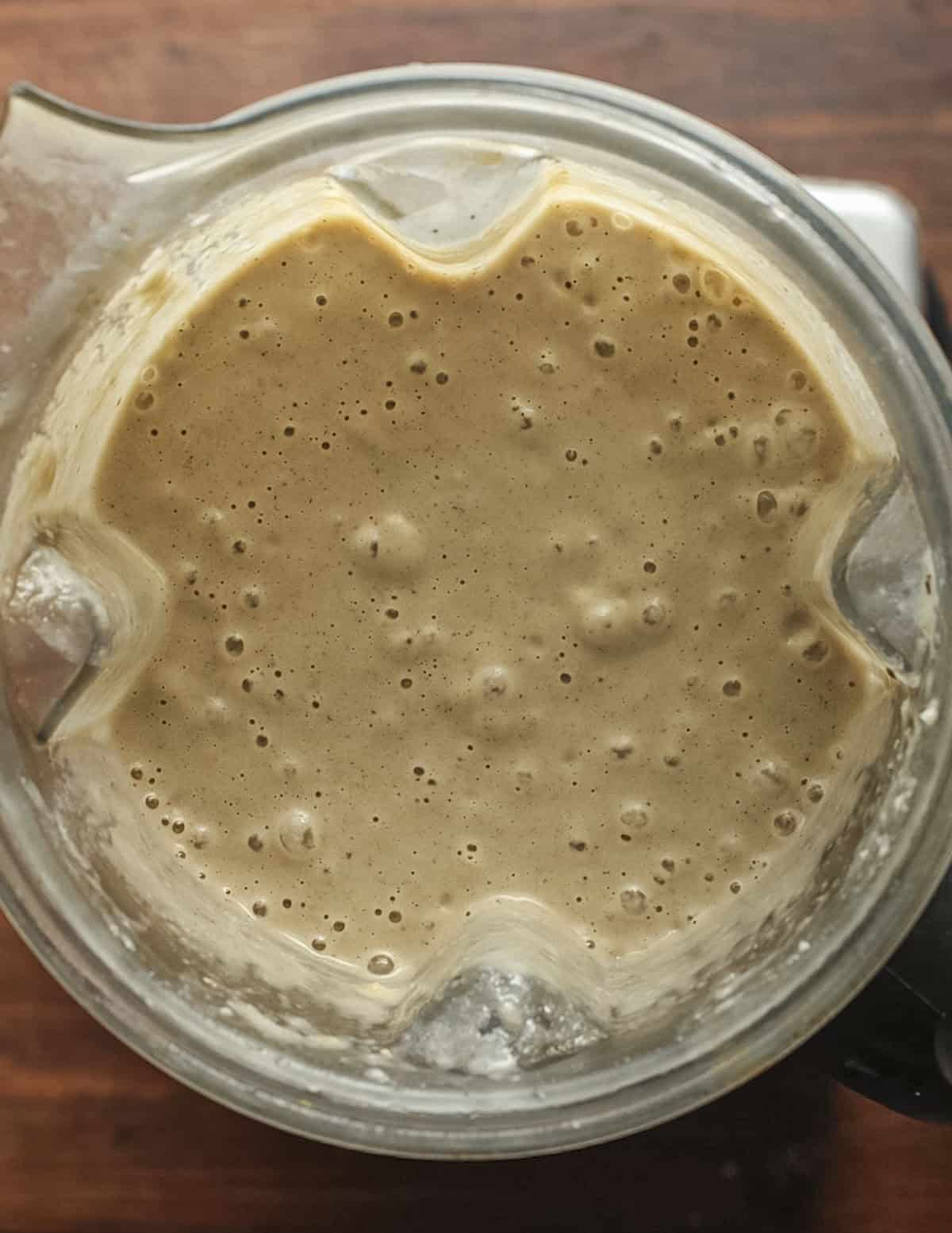 A Vitamix blender filled with pureed, cream of mushroom soup. 