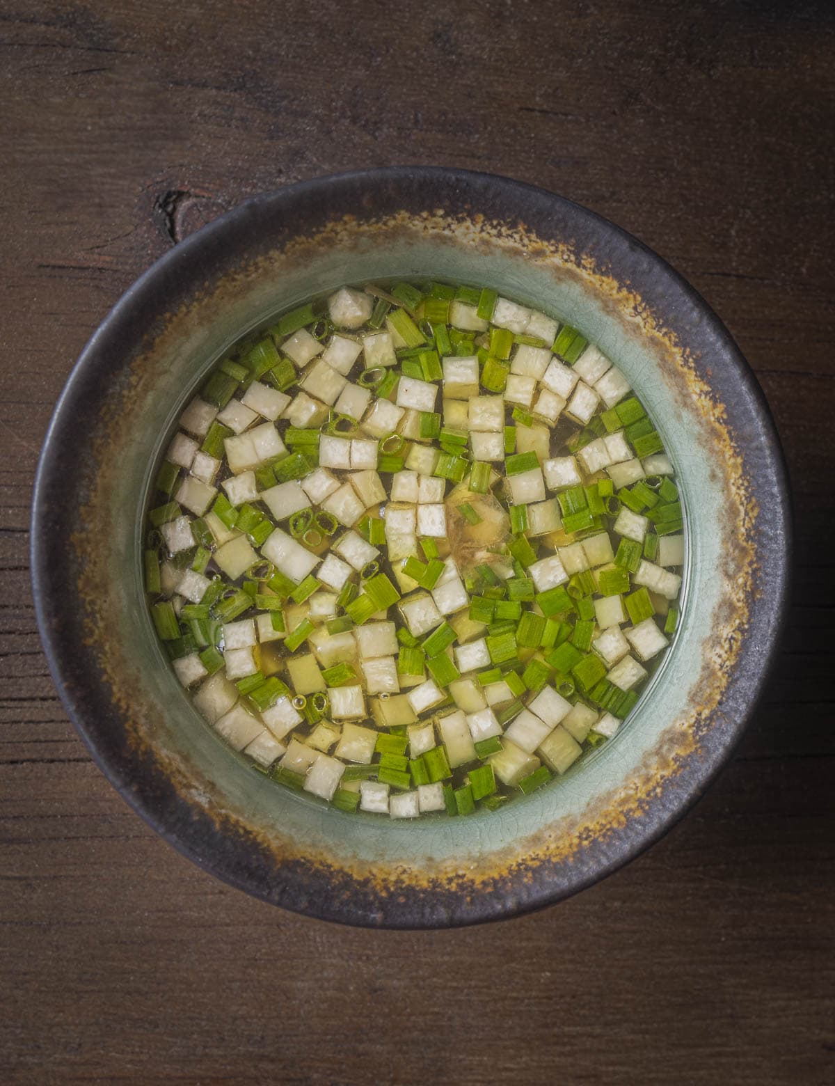 A bowl of finely diced king oyster mushroom soup with chives. 