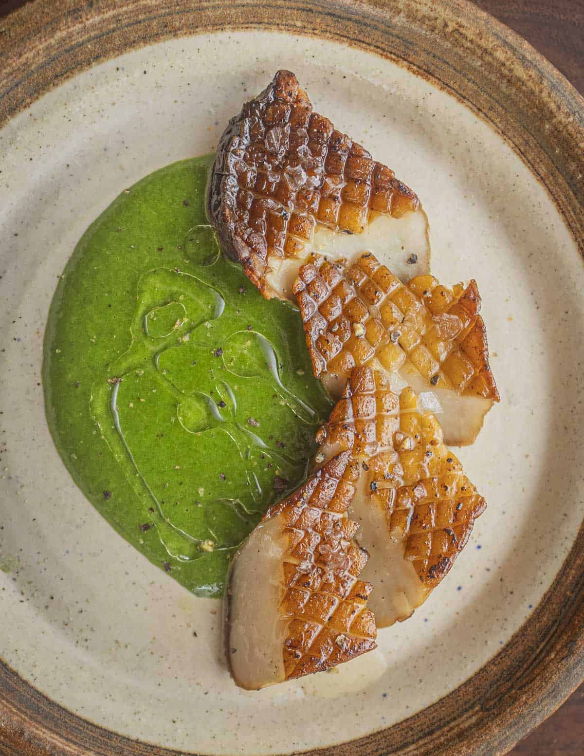 Golden brown king oyster mushrooms sliced and served with spinach puree. 
