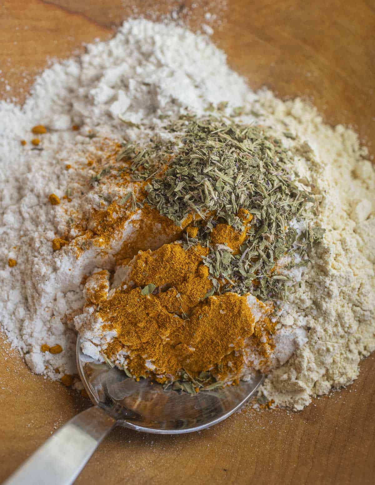 Mixing gram or chickpea flour with ground turmeric and herbs. 