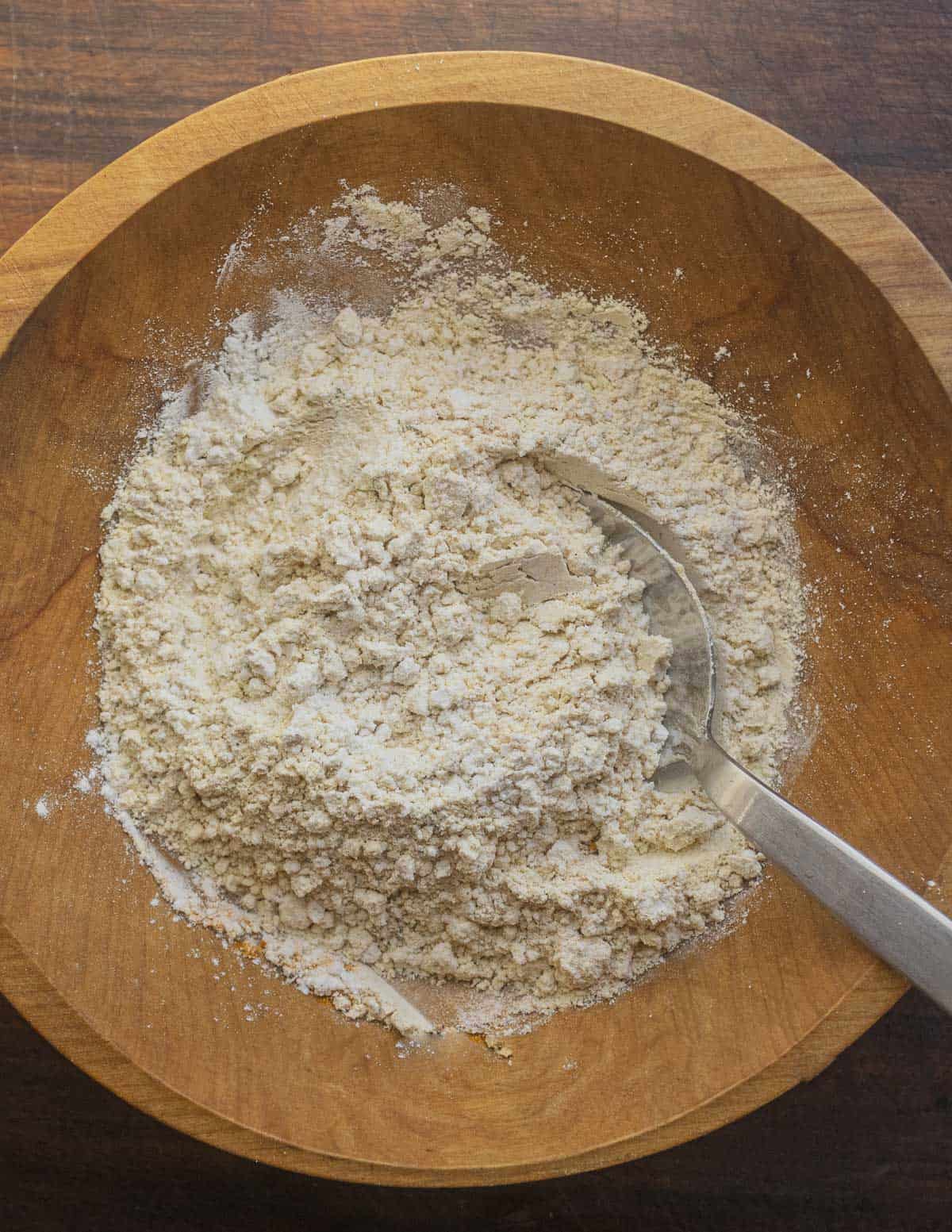 A bowl  of mixed chickpea flour, herbs, spices and all purpose flour mixed together for making flatbreads. 