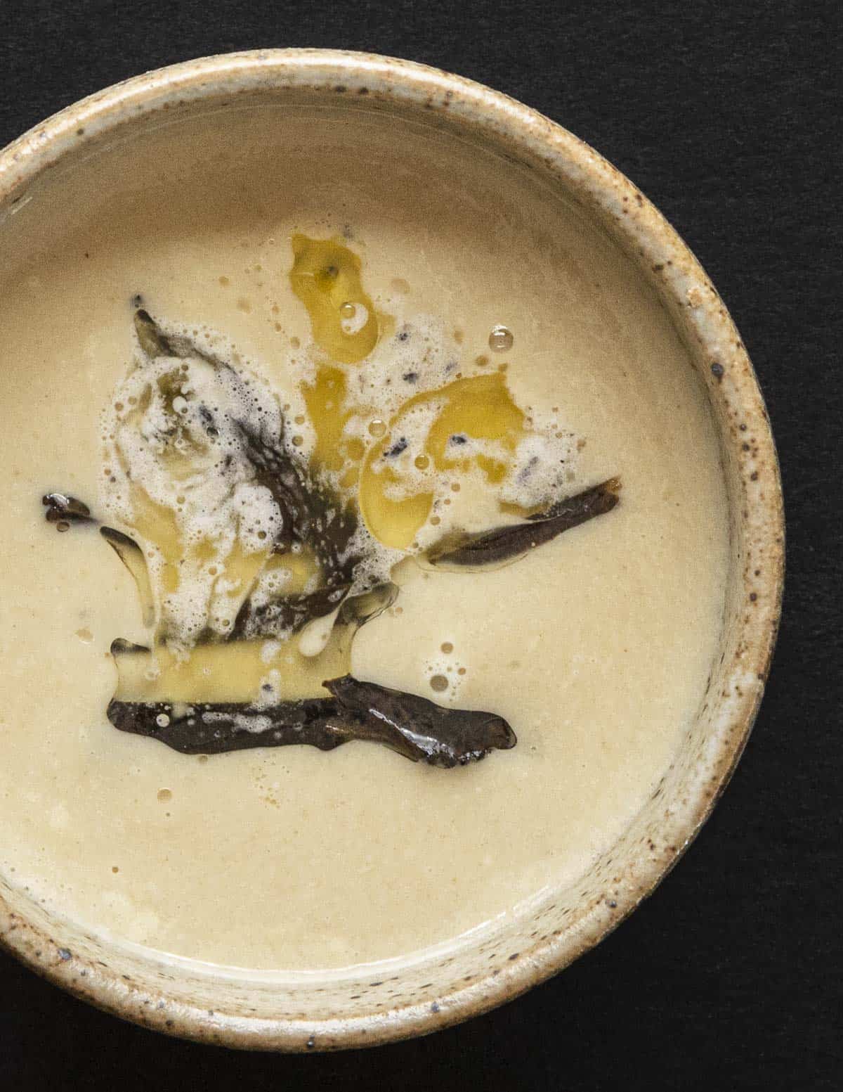 A bowl of morel mushroom soup with truffle butter and oil cured truffles. 