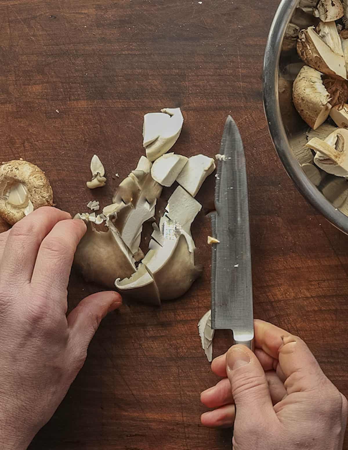 Cutting mushrooms into bite sized pieces. 