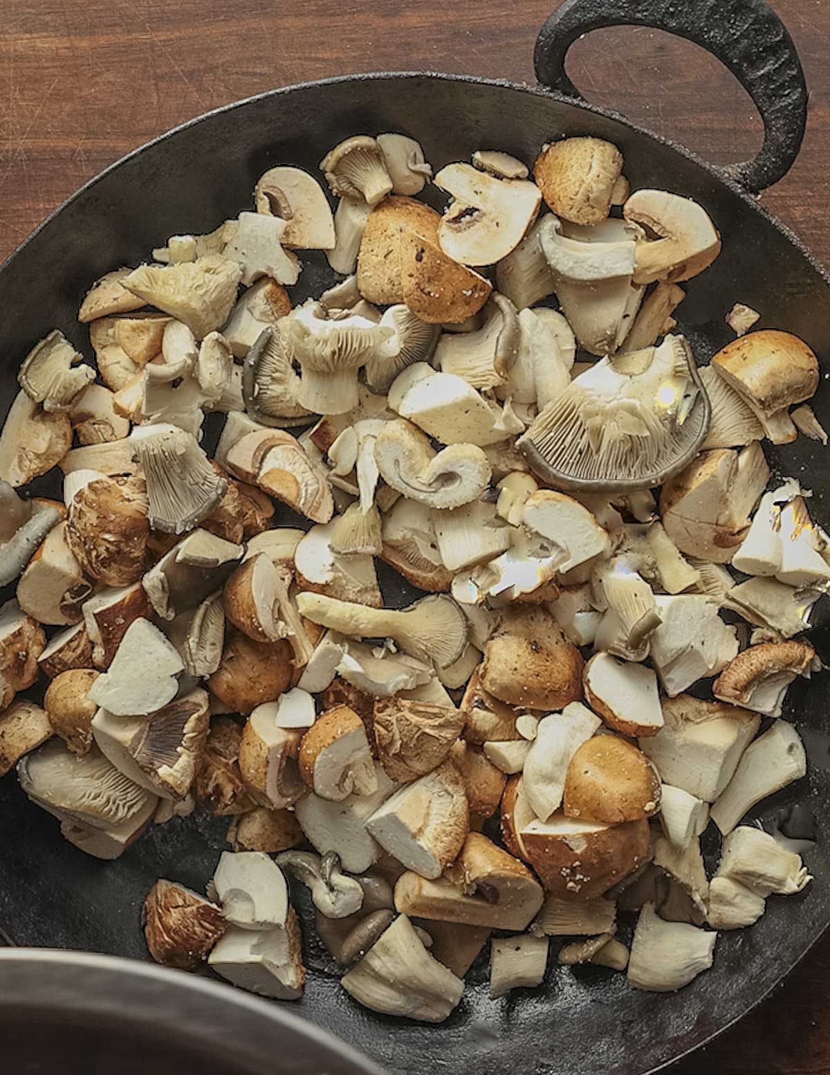 A pan full of seasoned mushrooms ready to go into the oven. 