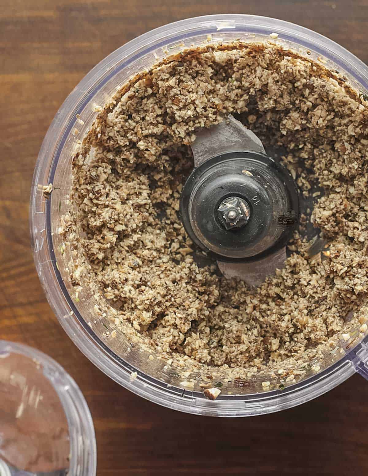 A food processor filled with ground cooked mushrooms. 
