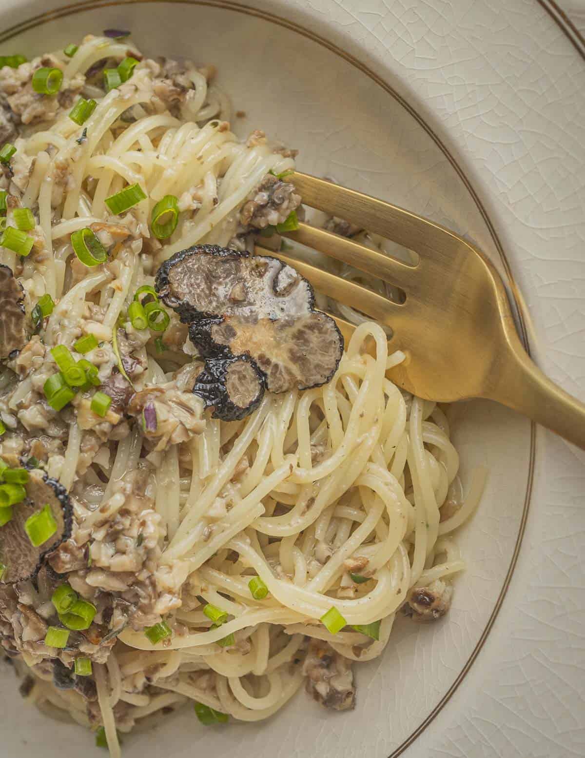 A bowl of angel hair pasta with truffle sauce. 