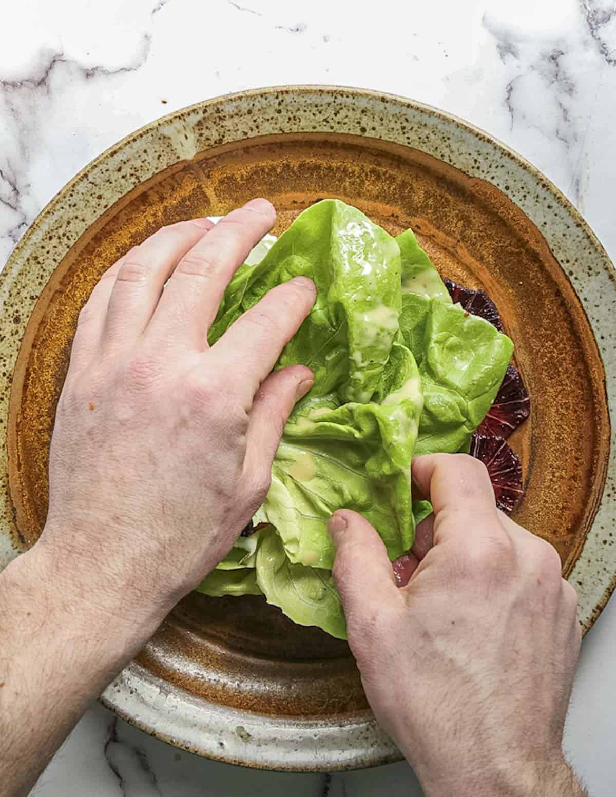 Layering butter lettuce leaves on a plate. 