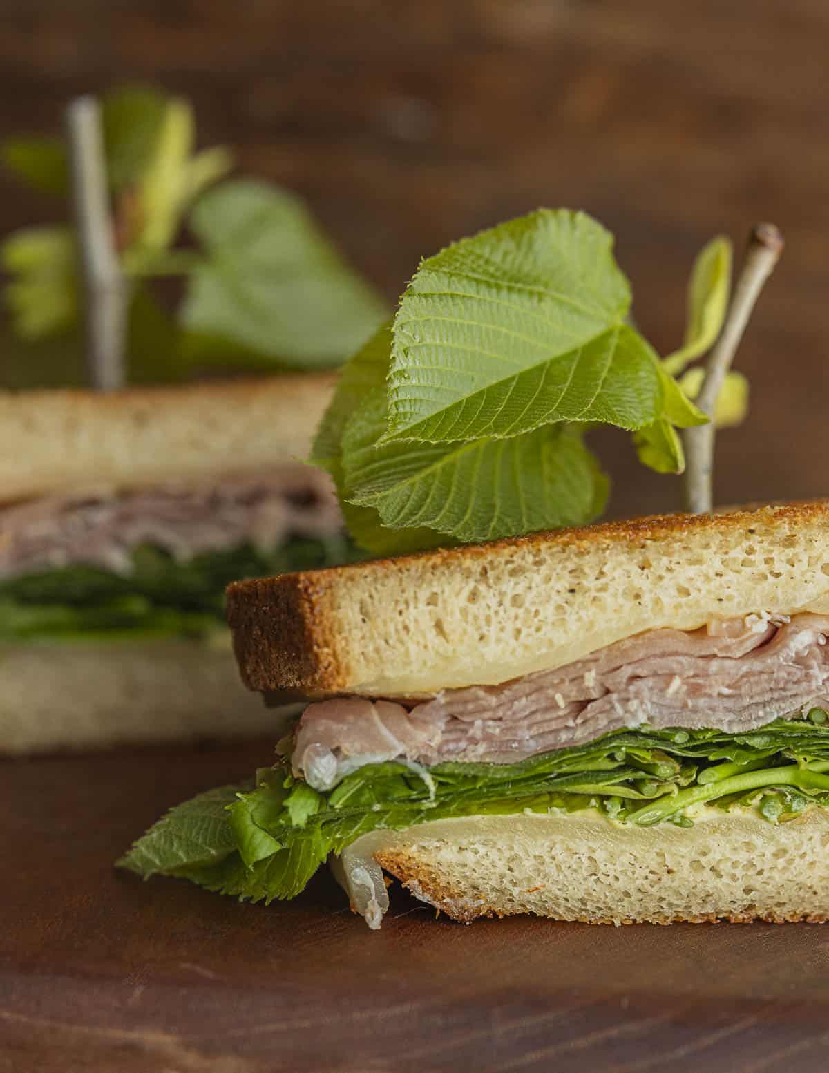 A sandwich made with edible basswood leaves and prosciutto ham.