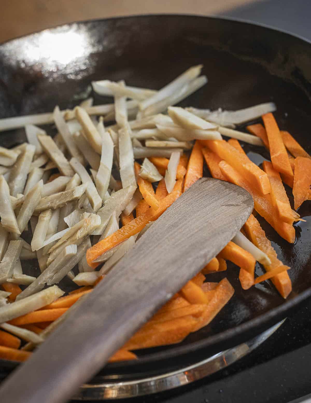 Stir-frying carrots and burdock for kinpira. 