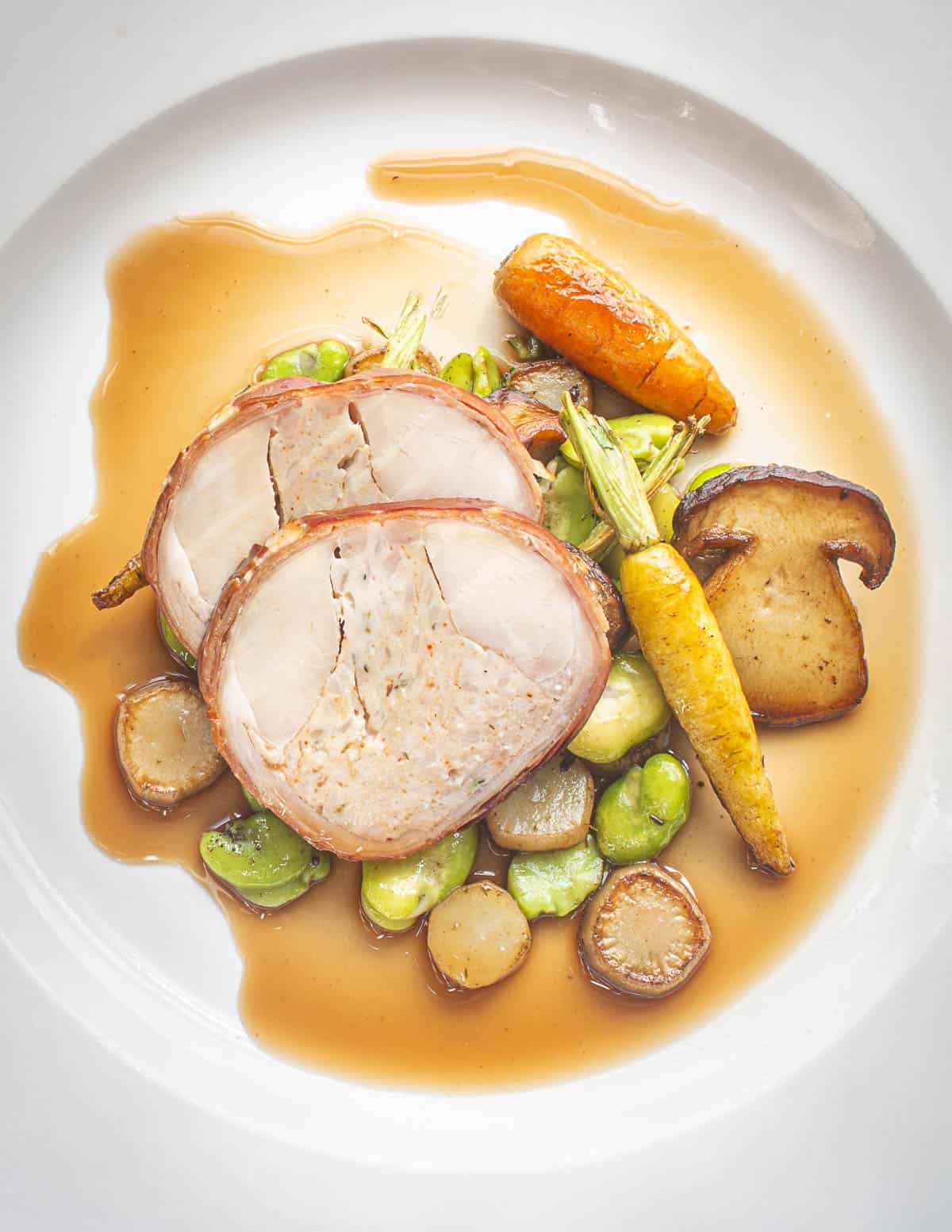 Stuffed rabbit saddle with early summer vegetables, burdock stems, Spring porcini and jus. 