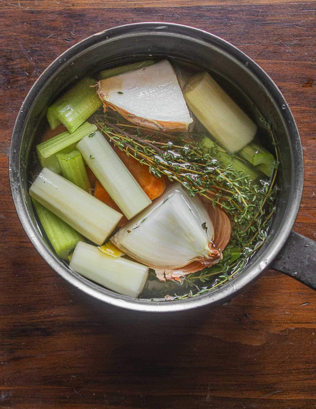 Burdock flower stalks or stems being cooked with vegetables in a pot. 
