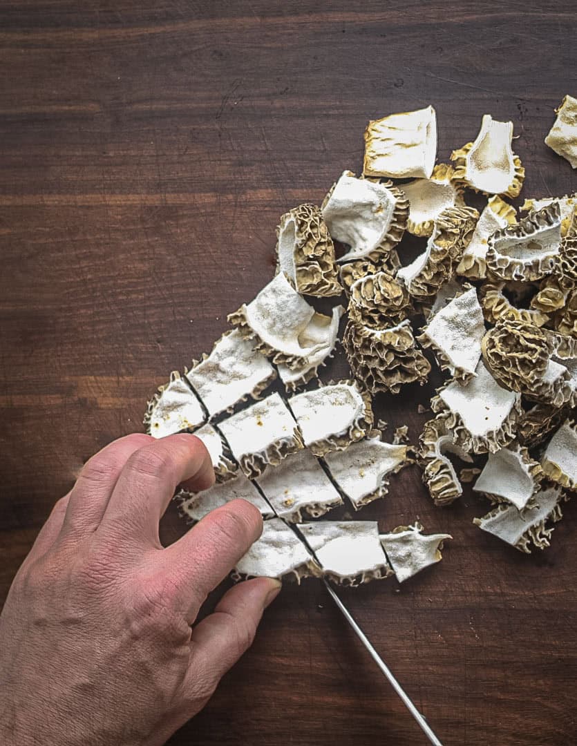 Slicing morel mushrooms into bite-sized pieces. 