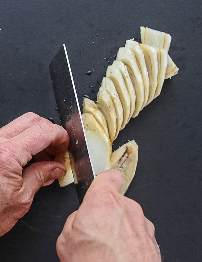 Cutting burdock roots into ¼ inch thick slices. 