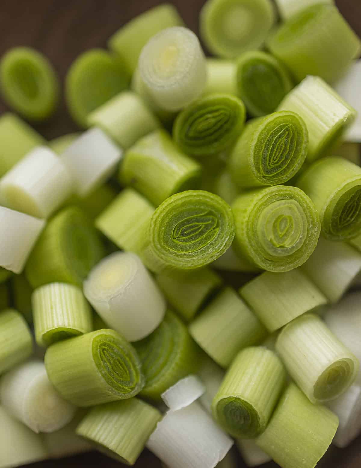 Close up image of green garlic cut into thick bite-sized rounds. 