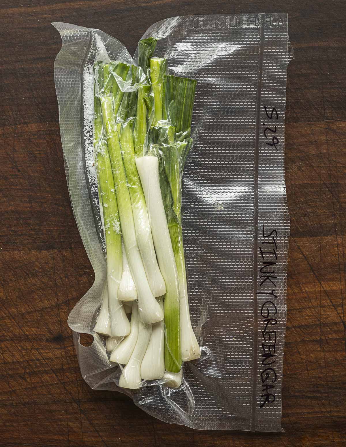 Green garlic mixed with salt fermenting in a vacuum bag. 