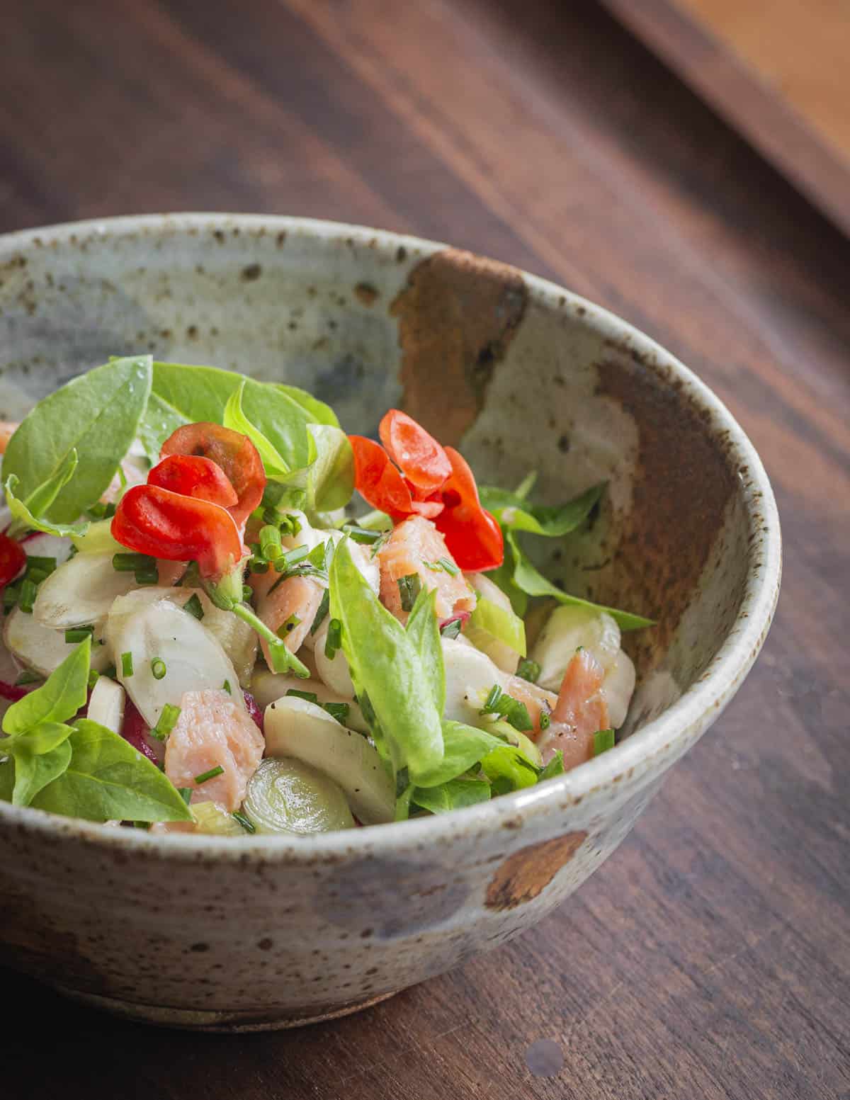A finished bowl  of cattail lateral rhizome salad with smoked trout. 
