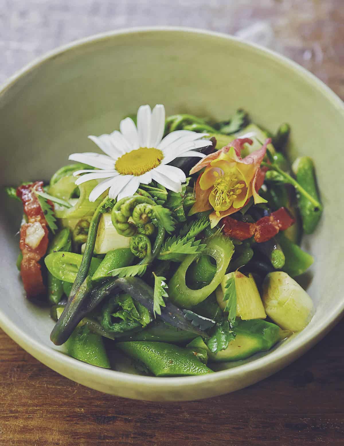 A salad of many edible wild shoots and herbs including cattails, thistles, ox eye daisy, mint, bacon and burnet leaves. 