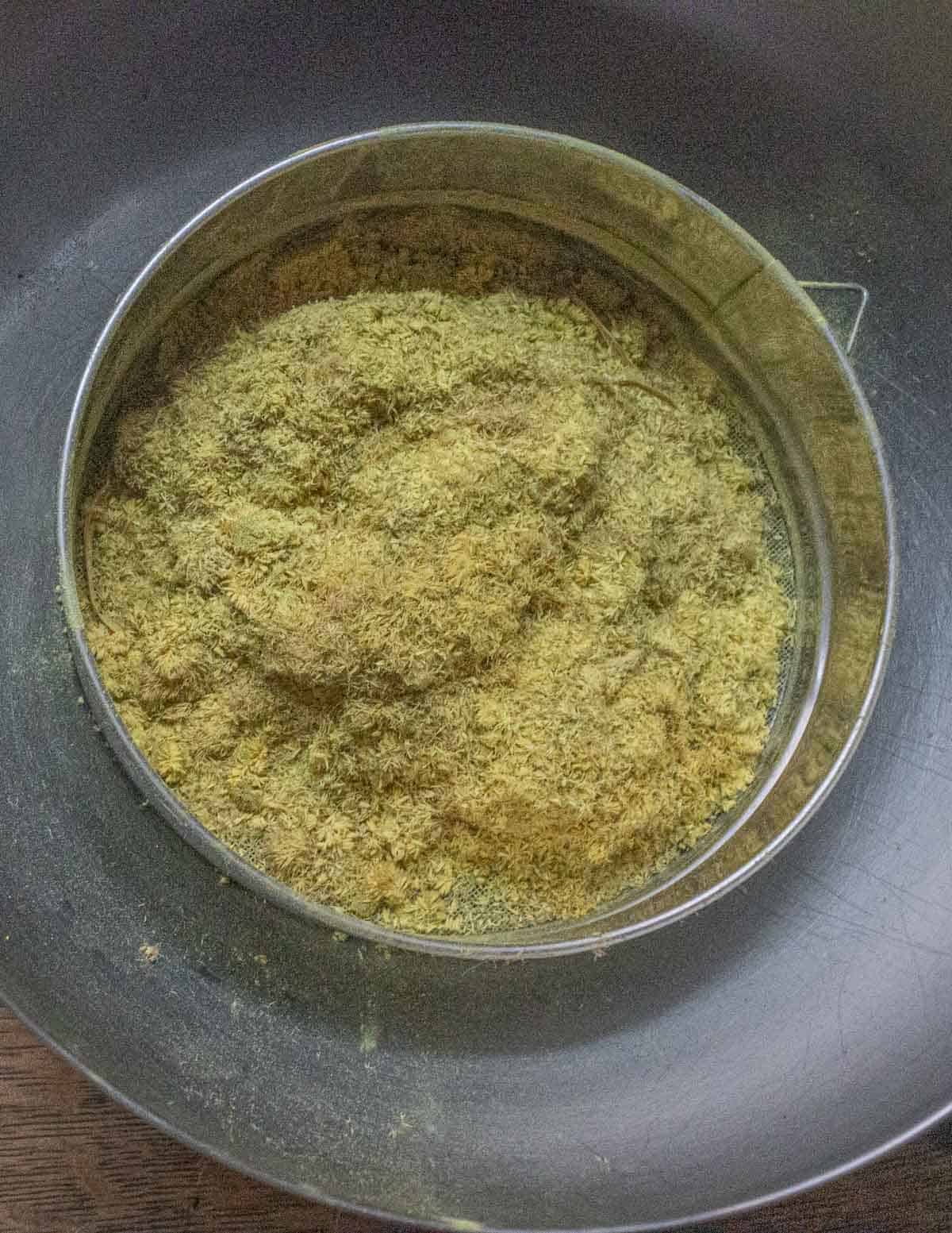 Sifting cattail pollen in a tamis sieve. 