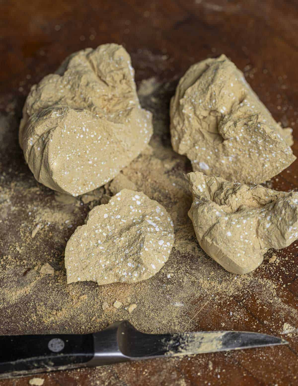 A block of Iraqi pollen candy being chipped into pieces for eating with a knife. 