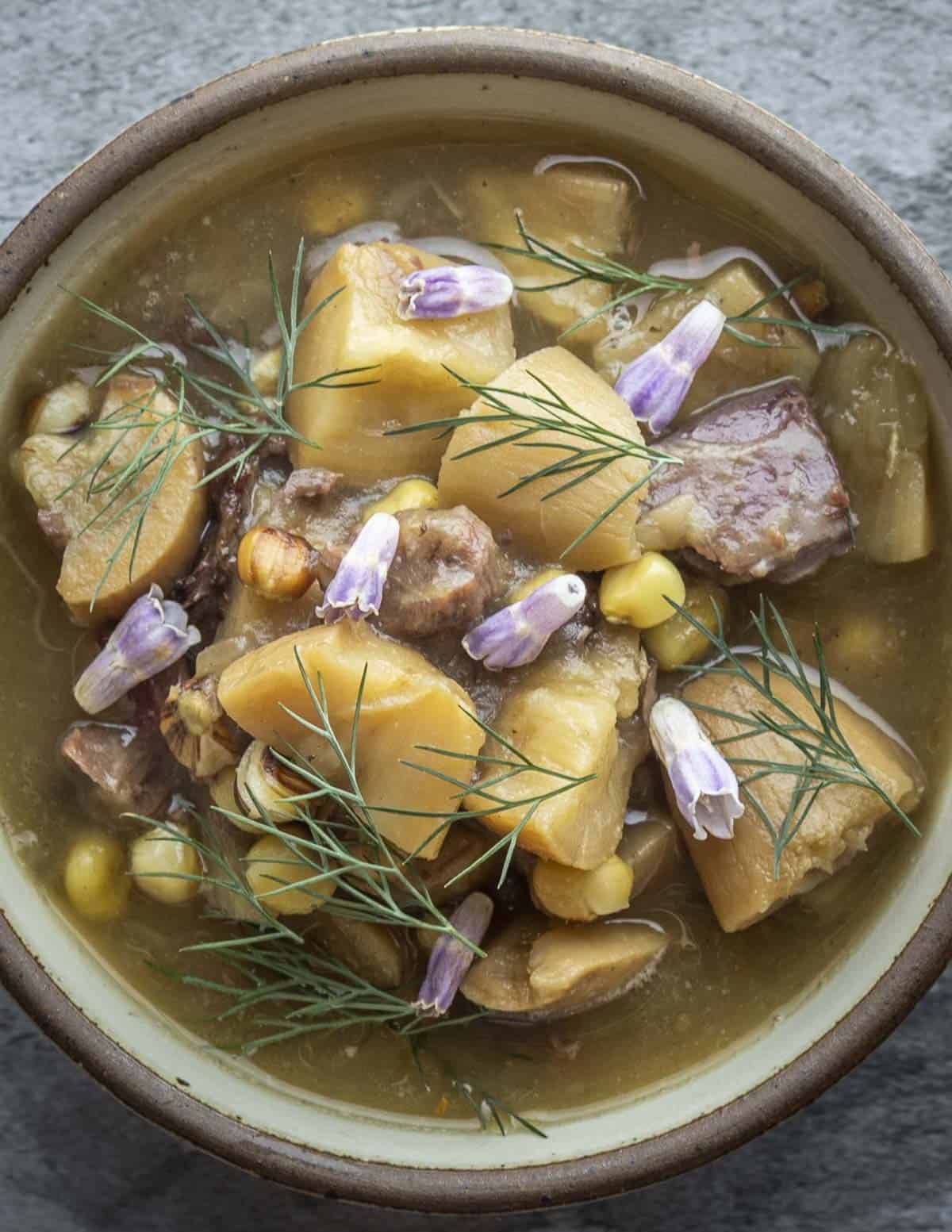 A soup made with timpsila roots and venison garnished with comfrey flowers. 