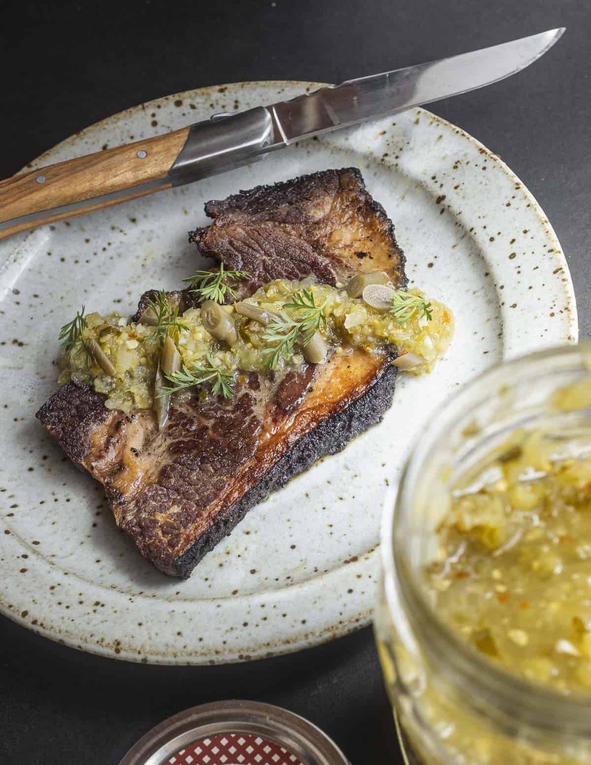 Leftover brisket fried in a pan garnished with garlic scape salsa.