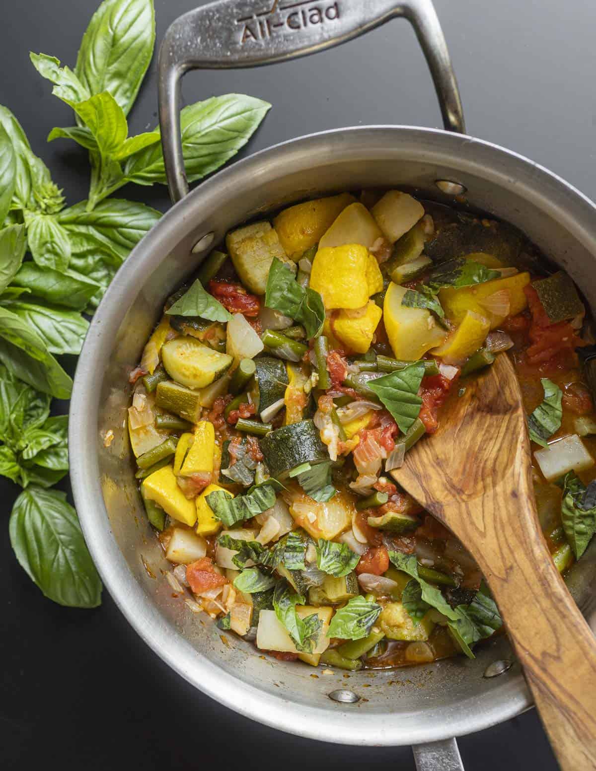 A pan of Italian vegetable stew with garlic scapes instead of green beans.
