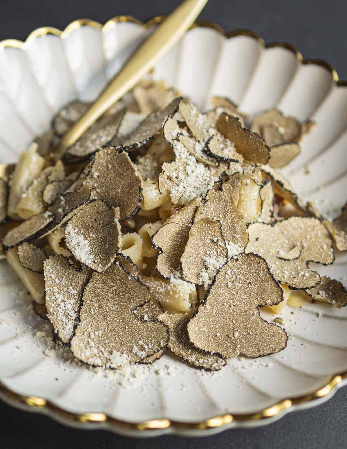 A bowl of pasta carbonara with shaved summer truffles (Tuber aestivum). 