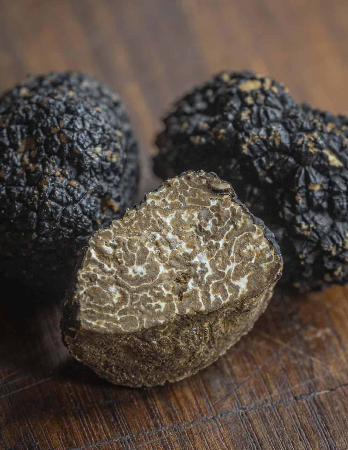 A close up image of Burgundy truffles or Tuber uncinatum sliced to show the inner brown gleba. 