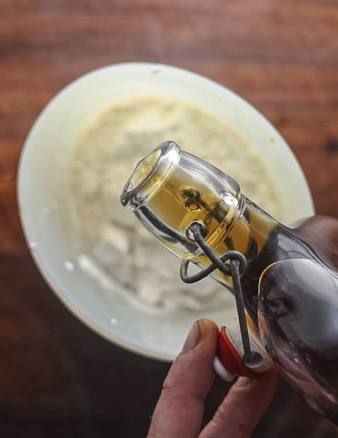 Adding vanilla extract to clafoutis batter. 