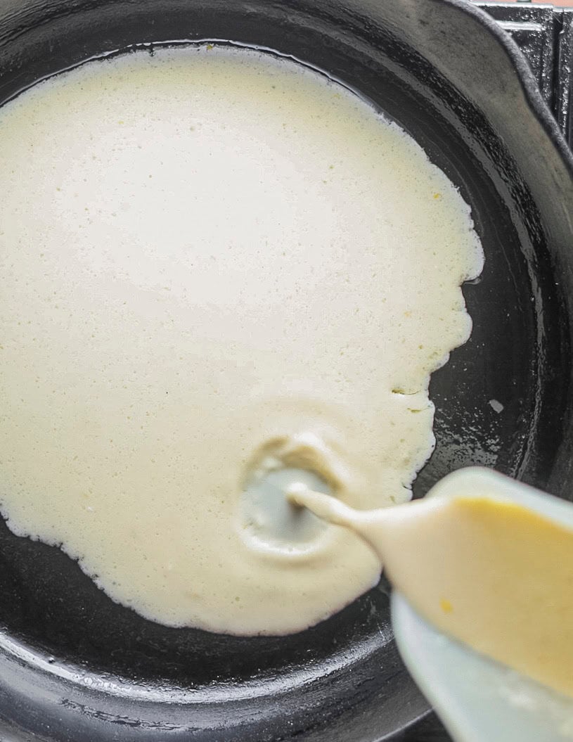 Pouring clafoutis batter into a cast iron pan. 