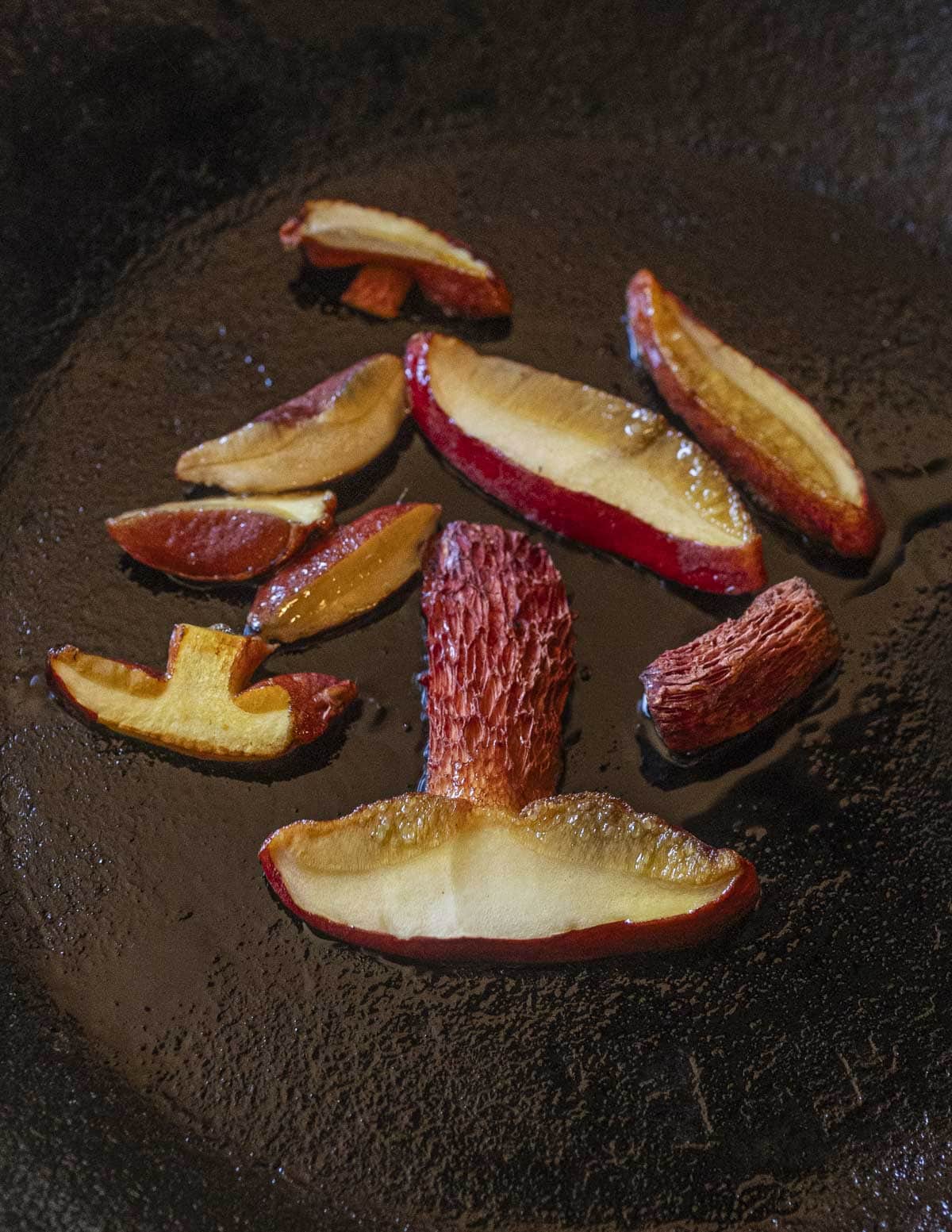 Frost bolete mushrooms in a pan showing the color transformation of the flesh from blue to yellow when the mushrooms are cooked. 