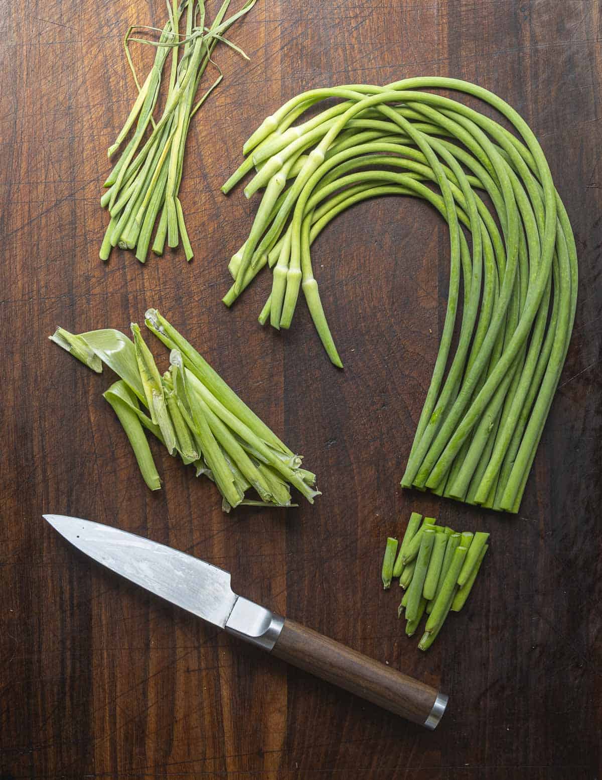 An image showing proper trimming of garlic scapes before cooking.