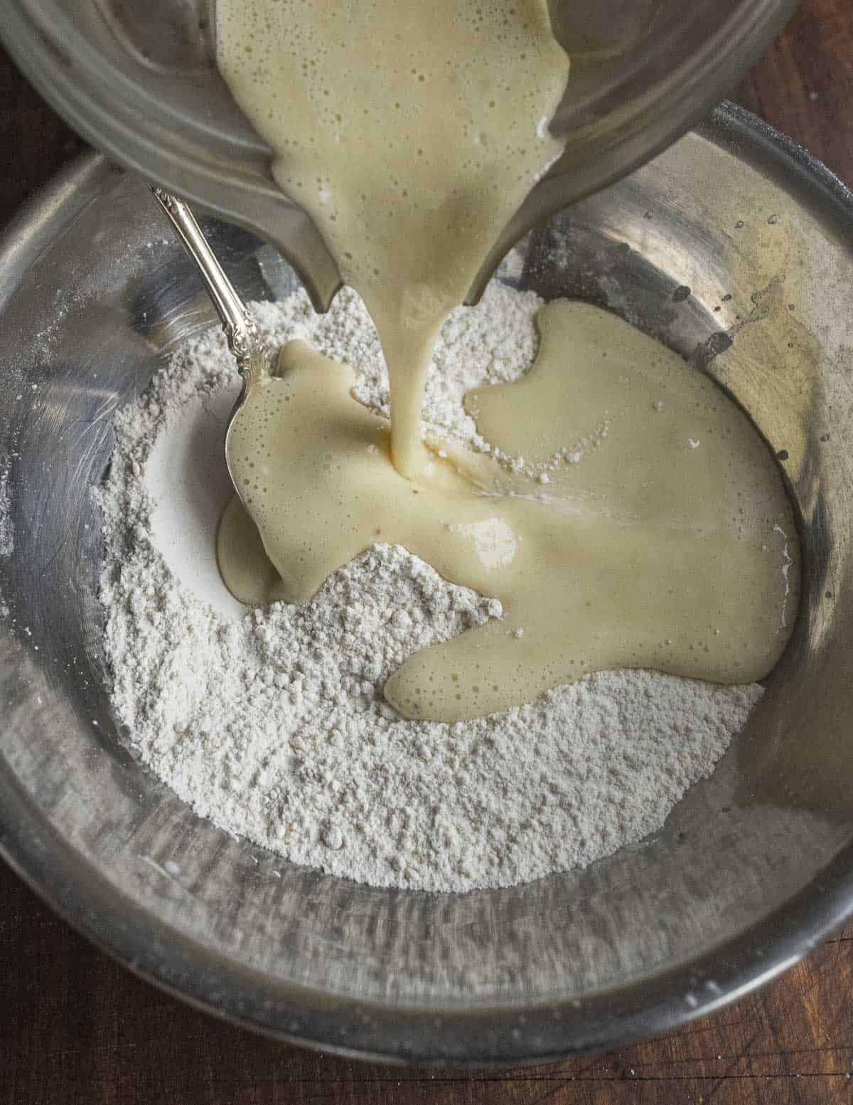 Mixing wet ingredients into dry ingredients to make pancakes. 