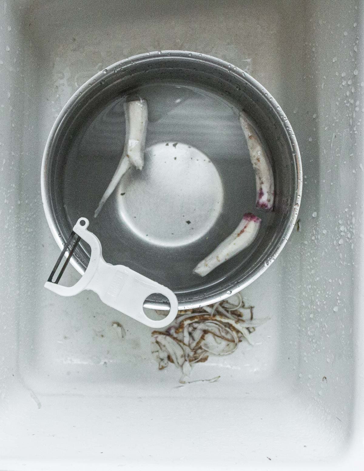 Peeling evening primrose roots with a vegetable peeler. 