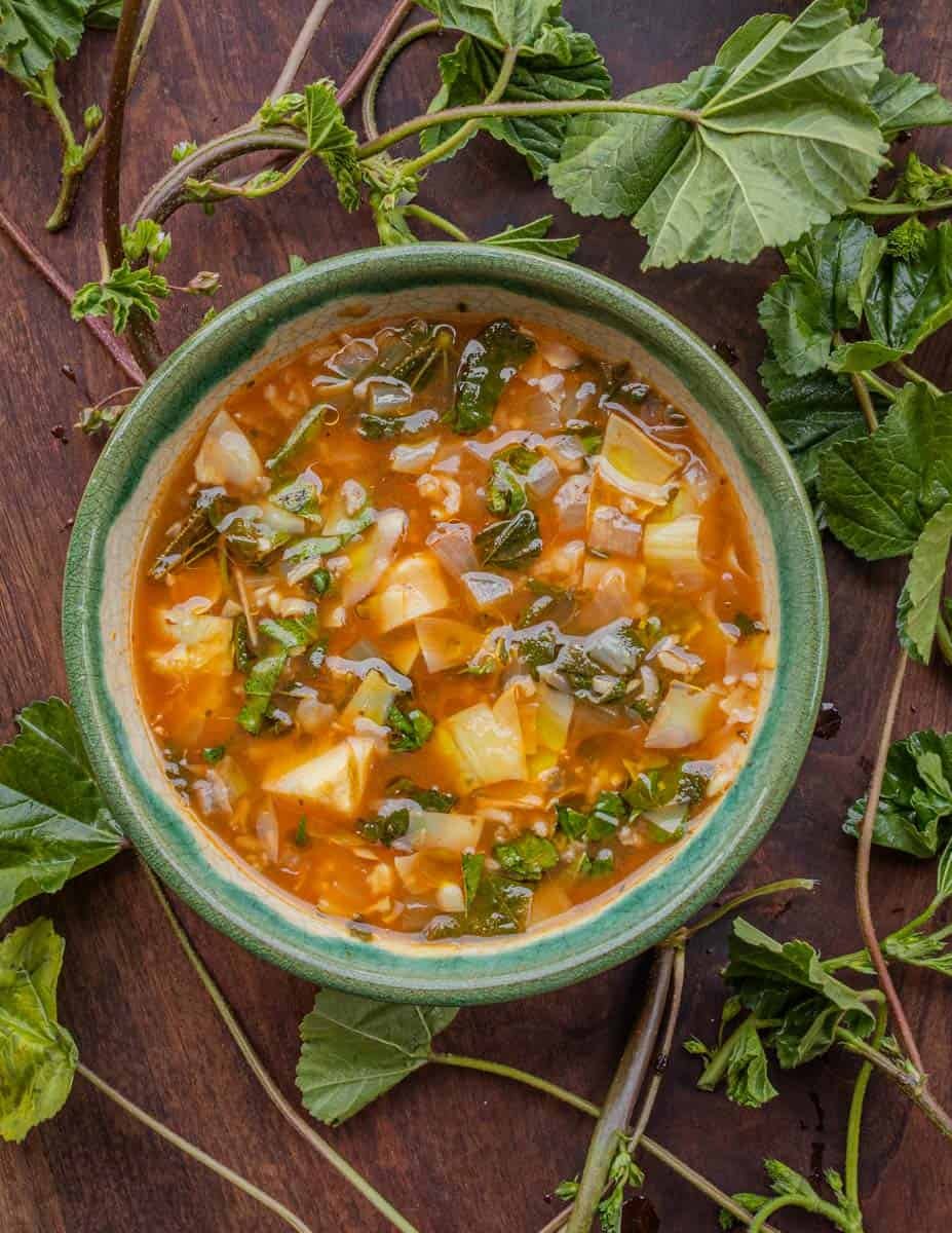 A bowl of Greek inspired soup made with mallow greens, artichokes, and rice.