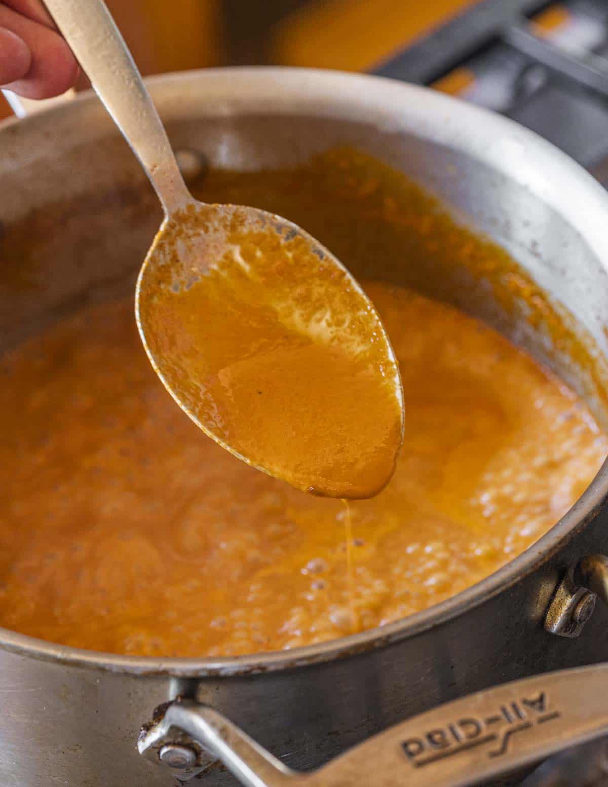 Boiling lobster stock in a pot to reduce it down to a concentrate.