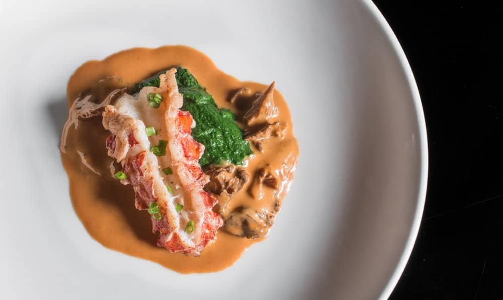 Lobster tail with yellowfoot chanterelles, dandelion puree and lobster sauce.