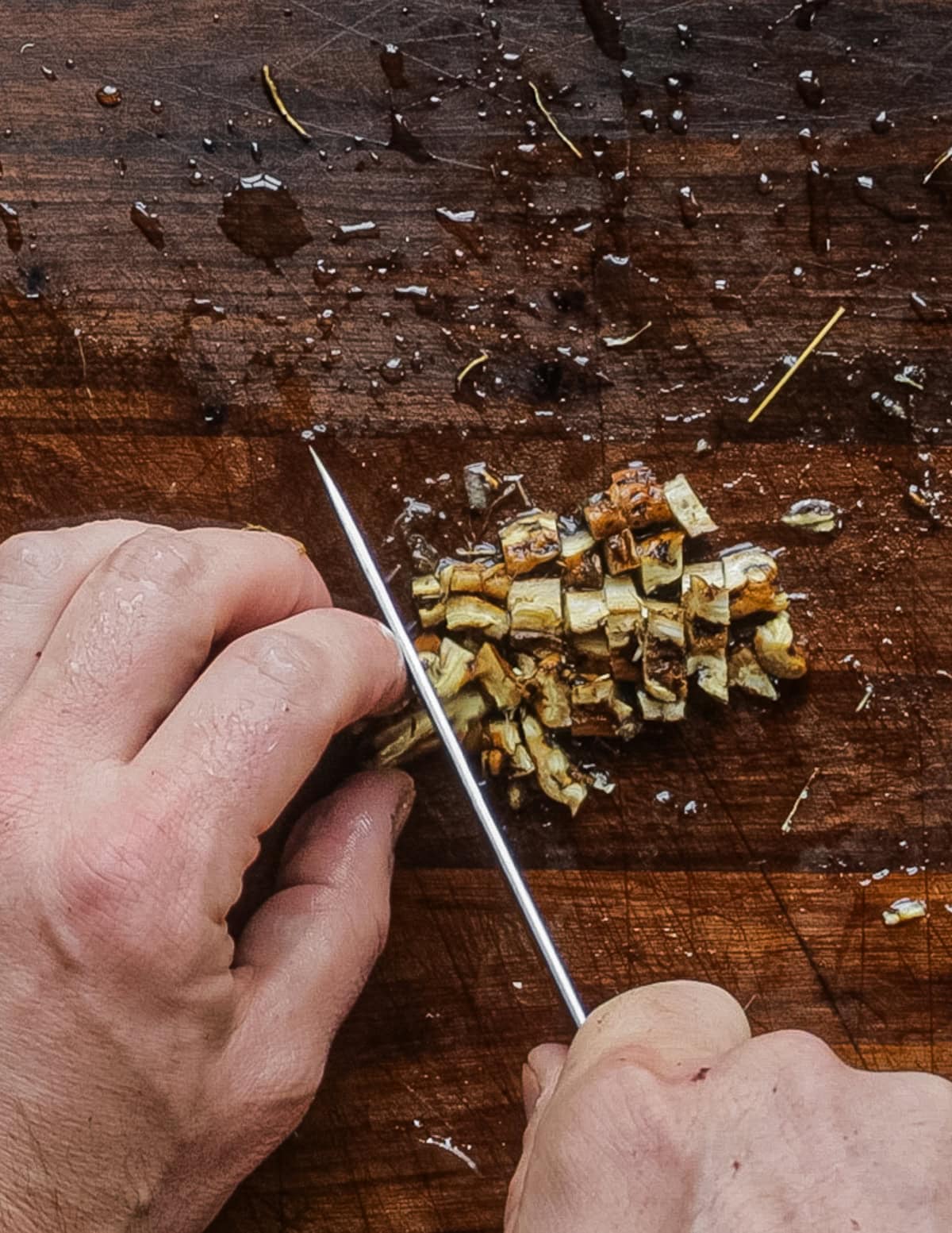 Cutting fresh dandelion root into pieces before dehydrating.