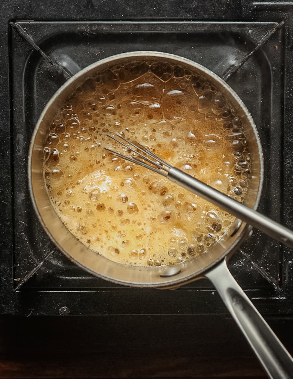 Boiling maple syrup in a small pot.