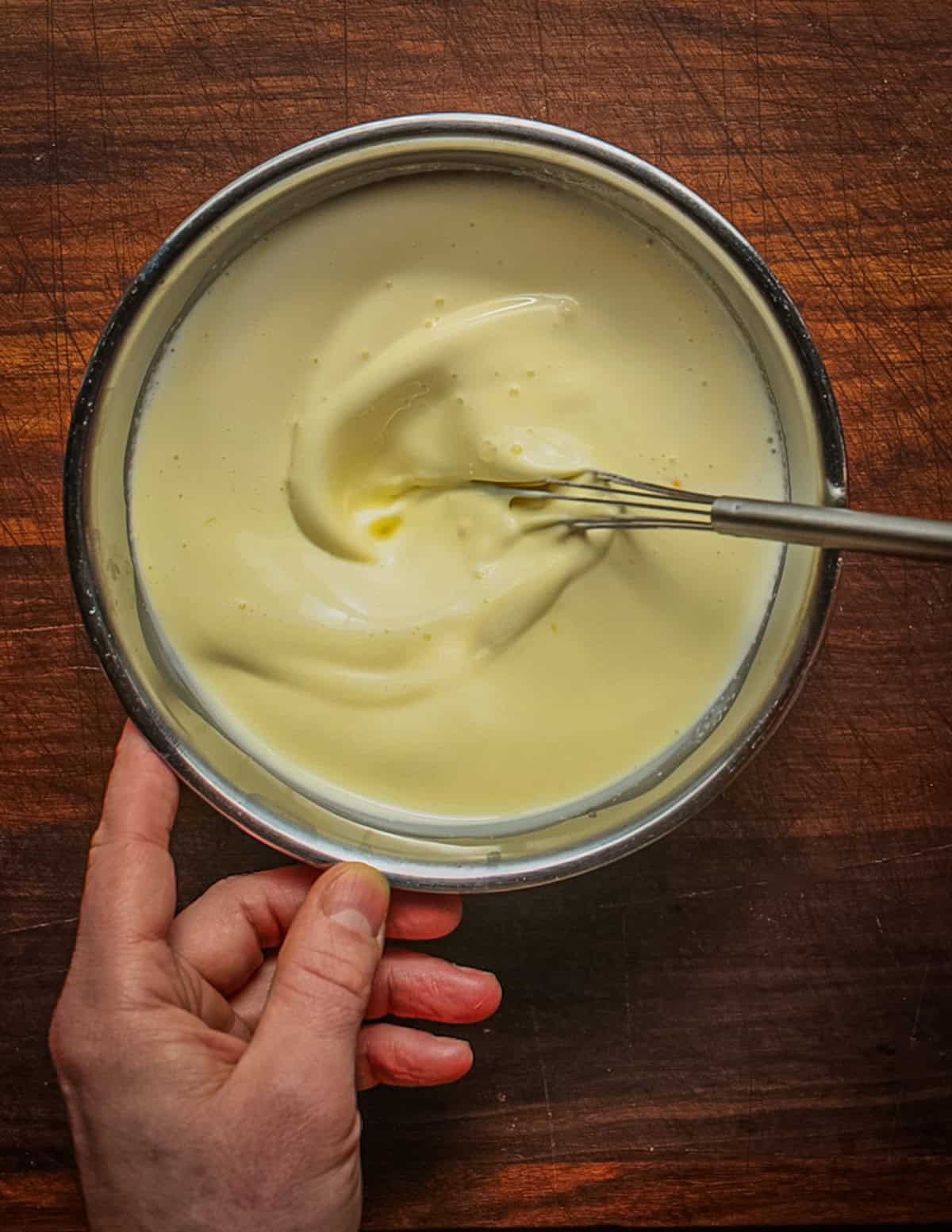 Whisking egg yolks and cream together to make a custard.