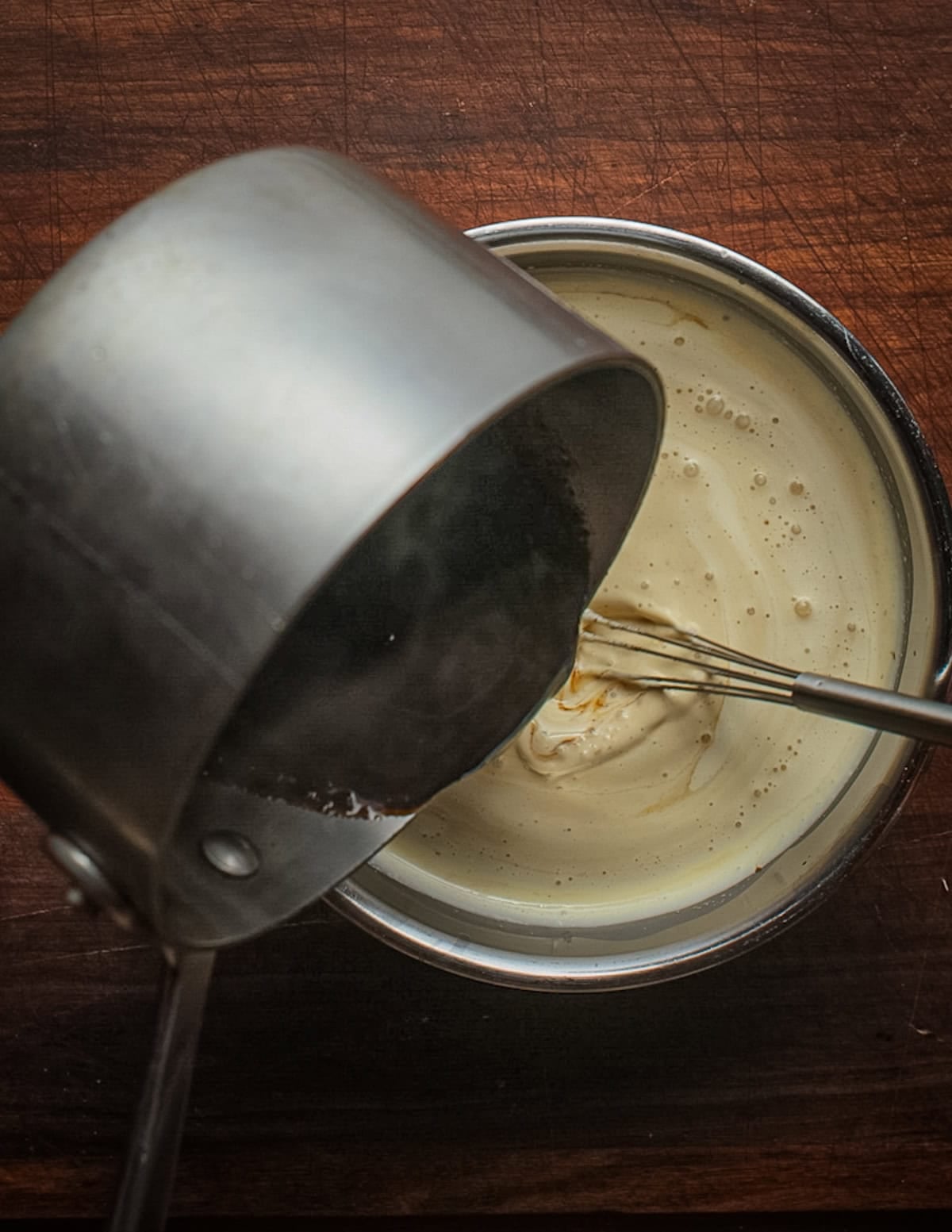 Pouring dandelion coffee into a pot of custard.