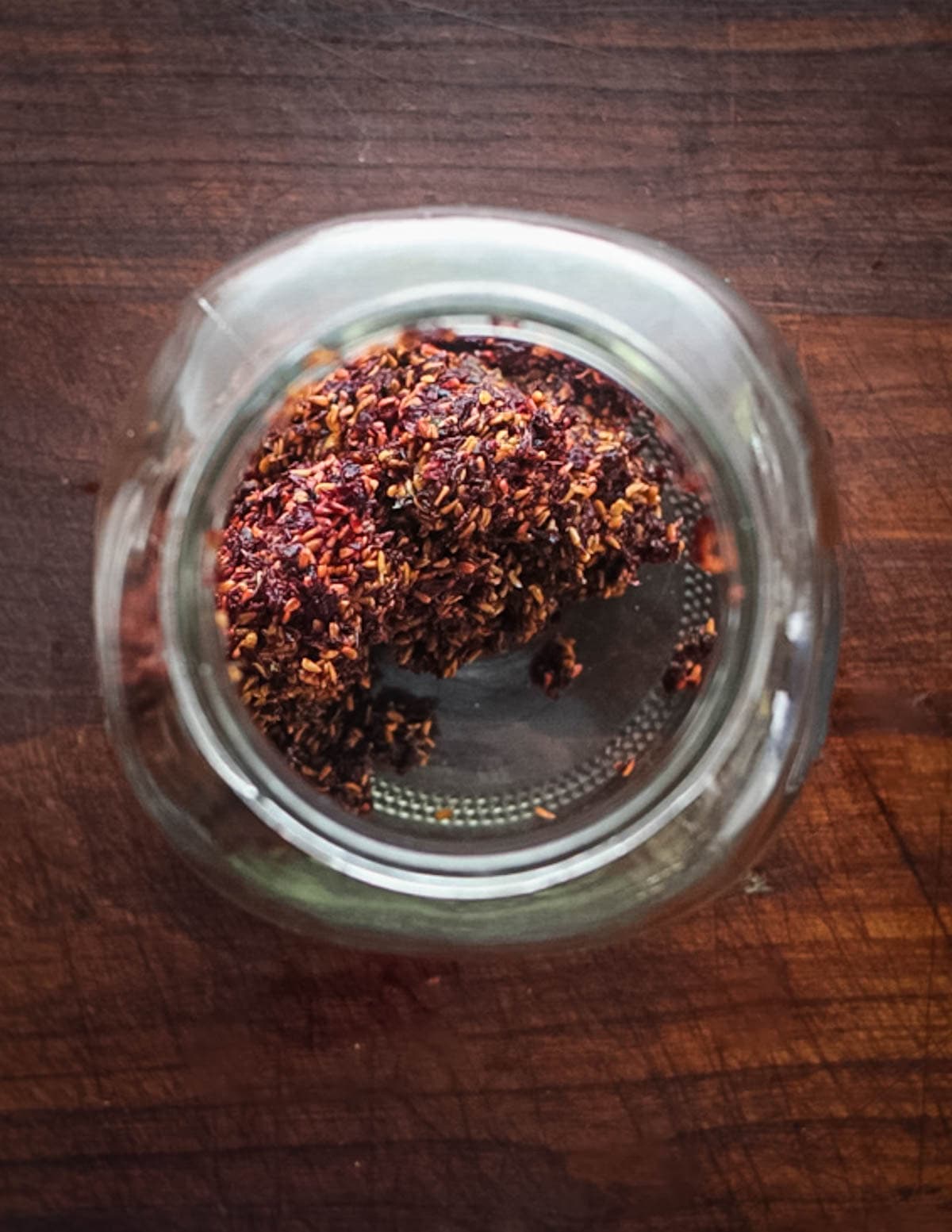 Putting elderberry seeds and skins in a jar.