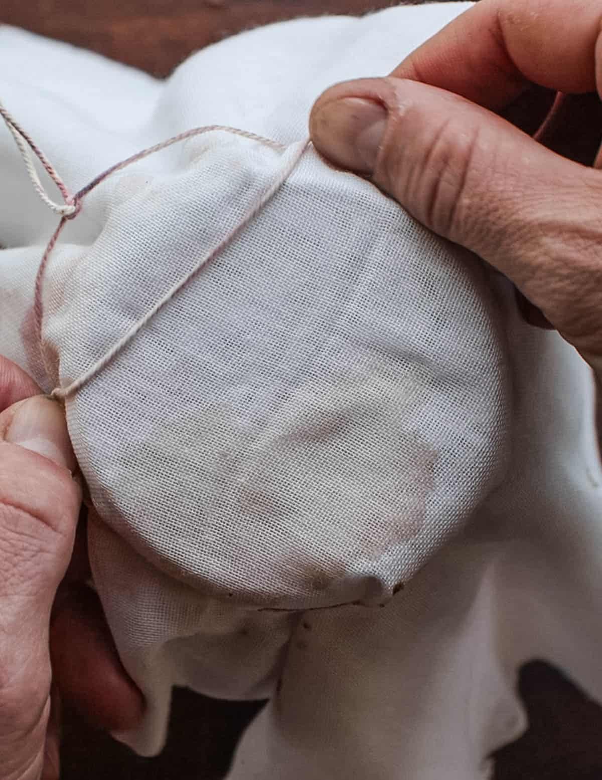 Covering a jar of elderberry vinegar with cheesecloth so it can breathe.