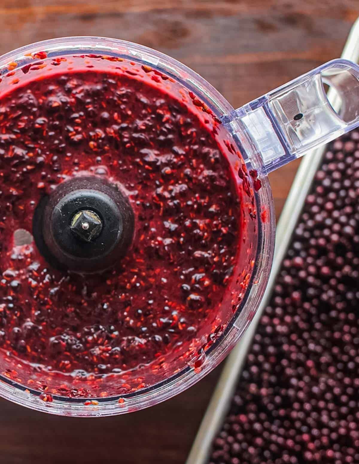 Pureeing elderberries in a food processor.